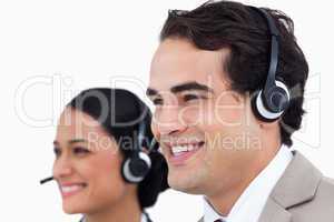 Close up side view of smiling telephone support employees