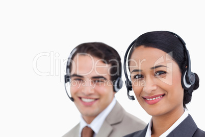 Close up side view of smiling telephone support employees at wor