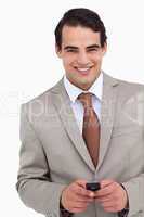 Close up of smiling salesman holding his cellphone