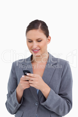 Close up of smiling tradeswoman typing text message Close up of smiling tradeswoman typing text message