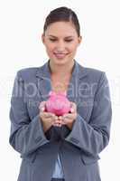 Smiling bank clerk with piggy bank