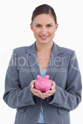 Smiling bank clerk holding piggy bank