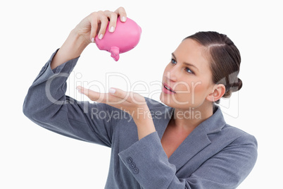 Bank clerk emptying piggy bank