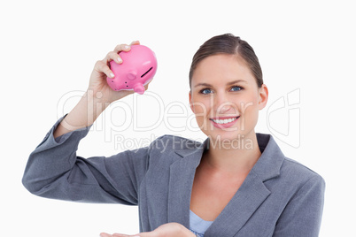 Smiling bank clerk with piggy bank in her hand