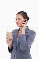 Tradeswoman with paper cup on her cellphone