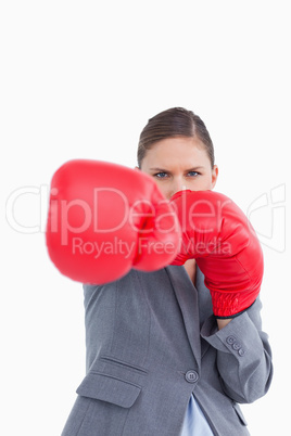Tradeswoman with boxing gloves attacking with right fist