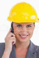 Close up of female architect with helmet on her cellphone