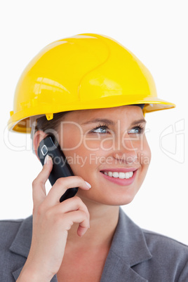 Close up of female architect with cellphone and helmet on