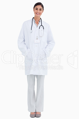 Smiling female doctor with hands in her pockets