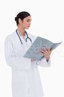 Side view of female doctor reading patients record
