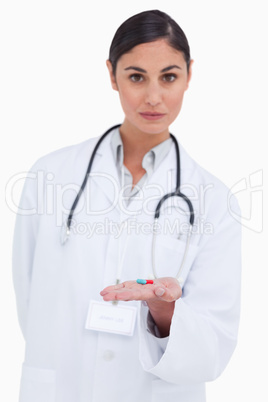 Female doctor holding pill in her palm