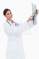 Side view of smiling female doctor holding x-ray