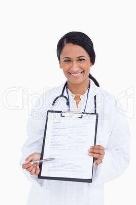 Close up of smiling female physician pointing at form