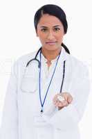 Female physician holding pills in her hand