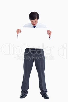 Tradesman looking at blank sign in his hands