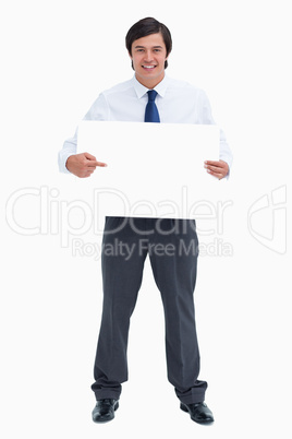 Smiling tradesman pointing at blank sign in his hands