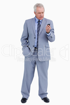 Mature tradesman looking angry at his cellphone