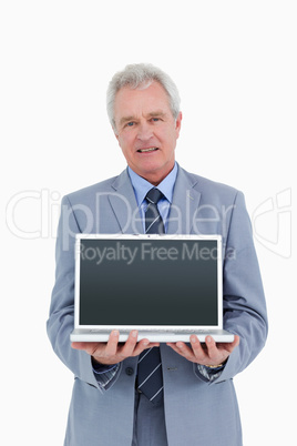 Mature tradesman presenting screen of his laptop