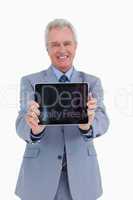 Smiling mature tradesman presenting screen of his tablet compute