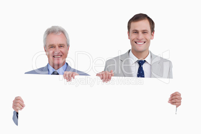 Smiling tradesmen holding blank sign