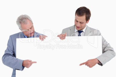 Tradesmen pointing at blank sign in their hands