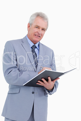 Smiling mature tradesman with pen and notebook