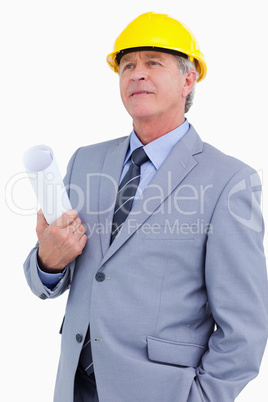 Mature architect wearing helmet and holding plans