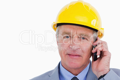 Confident mature architect with helmet on the phone