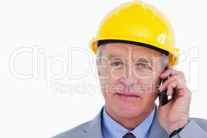 Confident mature architect with helmet on the phone