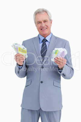 Smiling mature tradesman with cash in his hands