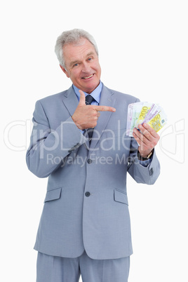 Mature tradesman pointing at his money