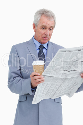 Surprised mature tradesman with news paper and paper cup