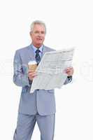 Mature tradesman holding news paper and paper cup