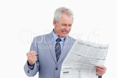 Mature tradesman cheering about news paper article