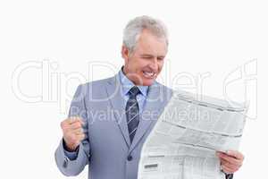 Mature tradesman cheering about news paper article