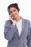 Smiling female call center agent adjusting her headset