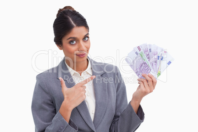 Female entrepreneur pointing at money in her hand