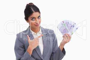 Female entrepreneur pointing at money in her hand