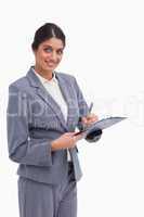Smiling female entrepreneur with clipboard and pen