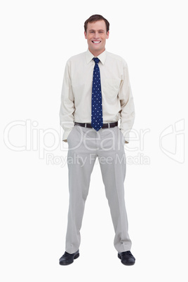 Smiling young businessman with his hands in his pockets
