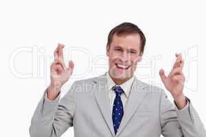 Close up of smiling businessman with his fingers crossed