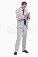 Smiling businessman reading text message