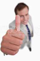 Close up of thumb up being given by smiling businessman