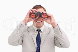 Smiling businessman using binoculars