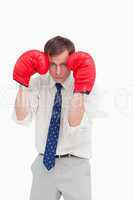 Businessman with boxing gloves taking cover