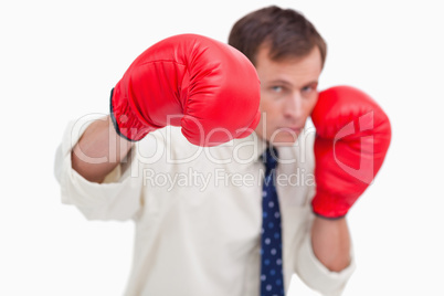 Punching businessman with boxing gloves