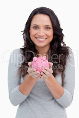 Piggy bank being held by smiling woman