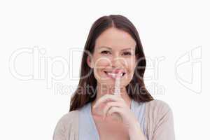 Close up of smiling woman asking for silence