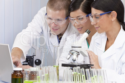 Interracial Team of Scientists In Laboratory With Laptop