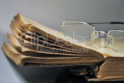 sheets of an old book with glasses